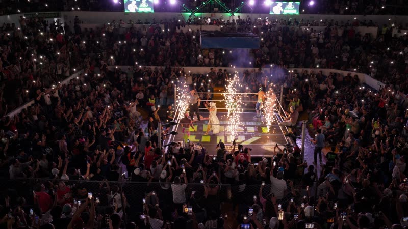 Función masiva de lucha libre independiente en Arena Qro con miles de espectadores, pirotecnia y luchadores en el ring